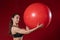 Portrait of a young woman holding a Swiss ball exercise and smiling at the camera. Live female fitness model image