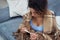 Portrait of a young woman at home with a viral infection. A woman looks at the reading of a thermometer. High body temperature.