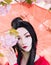 Portrait of young woman in image of japanese geisha near blooming sakura