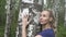 Portrait of the young woman with a long fair hair of the birch embracing a trunk in the birch wood