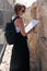 Portrait of young woman looking at map at Jaffa Gate walls in Jerusalem