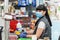 A portrait of young woman in a medical mask and gloves, working at the checkout in a supermarket. Concept of coronovirus,