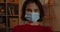 Portrait of young woman in medical protective mask looking to camera. Close up view of millennial female person with