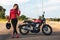 Portrait of young  woman posing front classical motorbike