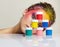 Portrait of young woman posing at the table with pyramid of small cans of paint