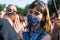 Portrait of young woman in protective mask in the crowd of people
