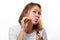 Portrait of a young woman smearing medicine on a pimple on her face. White background. Acne and pimples