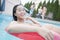 Portrait of young woman smiling and sitting on an inflatable tube in the pool