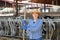 Portrait of a young woman standing on a cattle farm