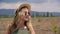 Portrait young woman in sunglasses and hat on field and mountain background. Beautiful woman face in hat and sun glasses