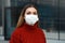 Portrait of young woman with surgical mask ready for mass vaccination looks at camera