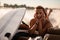 portrait of young woman in swimwear lying on edge of boat with wakesurf board