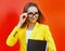 Portrait of young woman wearing a eyeglasses, yellow suit with folder