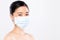 Portrait of young woman wearing a face mask, isolated on white background. Flu epidemic, dust allergy, protection against virus.