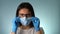 Portrait of a young woman wearing personal protective equipment. Medical mask and rubber gloves. Coronavirus pandemic.