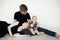 Portrait of young wonderful family in dark clothes with plump cherubic baby infant toddler sitting on white background.