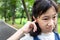 Portraits of asian little girl stressed putting a finger in to her ear,annoyed expression,closeup of cute child having any