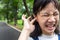 Portraits of asian little girl stressed putting a finger in to her ear,annoyed expression,insect in the ear,closeup of cute child