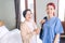 Portraits of Asian woman nurse wearing scrubs standing with Senior Asian woman in the bedroom. Caregiver visit at home.