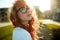 Portraits of a charming red-haired girl with a cute face. Girl posing for the camera in the city center. She has a wonderful mood