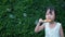Portraits of cute black long-haired Asian girls playing fun by blowing soap bubbles happily in garden.