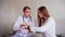 Portraits of doctor explains patient how to use smart Watch to monitor their health and sit on couch in hospital`