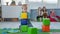 portraits of little boy with down syndrome building tower of colored bricks during educational activities for children