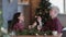 Portraits of young happy couple talking at table during Christmas holiday. Guys smiling, laughing and drinking champagne