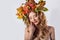 Portraiture style fashion beautiful girl with red hair fall with a wreath of colored leaves and mountain ash color bright tre
