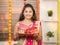 Portrit Shot of Indian Married woman in traditional dress holding Karva Chauth Thali or plate during Hindu Indian