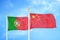 Portugal and China two flags on flagpoles and blue sky