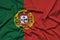 Portugal flag is depicted on a sports cloth fabric with many folds. Sport team banner