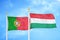 Portugal and Hungary two flags on flagpoles and blue sky