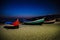 Portugal, Nazare beach, colored wooden boats on the beach at night