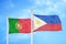 Portugal and Philippines two flags on flagpoles and blue sky