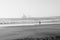 PORTUGAL, Praia near Sines. Beach viewed from down with a fisherman. Industial zone in black and white with big vawes and misty,