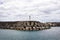 Portugal, San Miguel. White fluffy clouds in the sky, lighthouse and marina of Vila Franca do Campo, Azores.