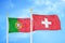 Portugal and Switzerland two flags on flagpoles and blue sky
