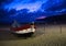 Portugal, twilight over Nazare beach, red wooden boat