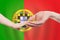 Portugese baby and parent hands on the background of flag of Portugal Help, aid, support, charity concept