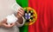 Portugese woman with money bank on the background of Portugal flag. Dotations, pension fund, poverty, wealth, retirement concept