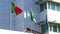 Portuguese and Brazilian flags flying side by side on a modern white building