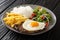 Portuguese dish Bitoque made from beef steak  topped with a fried egg served with rice and french fries, salad closeup in the