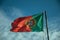 Portuguese flag fluttering on blue sky