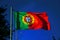 Portuguese flag fluttering in the blue sky