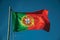Portuguese flag fluttering in the blue sky