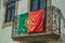 Portuguese flag on iron railing in a balcony from an old building