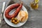 Portuguese smoked sausage, olives and corn bread broa on ceramic background