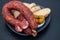 Portuguese smoked sausage, olives and corn bread broa on ceramic background