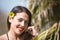 Posed portrait of a beautiful young woman with long brown hair, wearing a swimming costume and a black silk sarong. The woman has